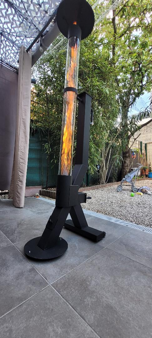 Flamesa pelletkachel brandt onder een pergola op een terras met keramische tegels