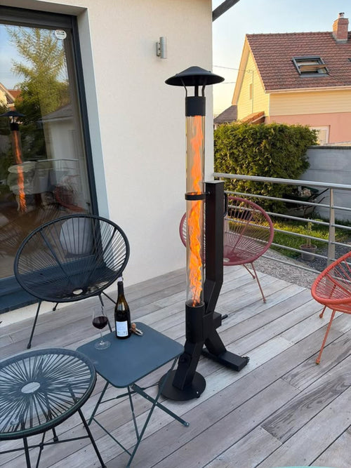 Terraskachel op pellets brandt op een terras met wijn en zwarte designstoelen bij een moderne woning