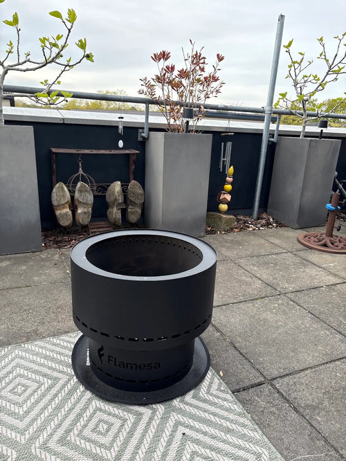 Flamesa vuurkorf op een buitenkleed op een terras met betonnen tegels
