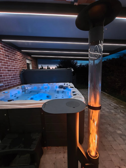 Terraskachel op pellets met bijzettafel naast een verlichte jacuzzi onder een overkapping