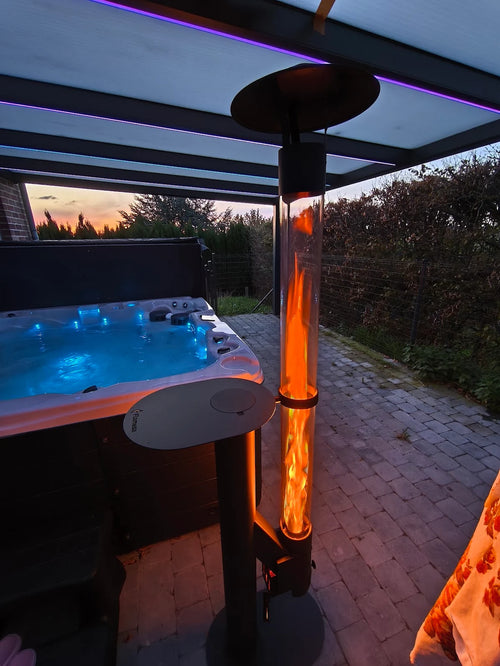 Flamesa pelletkachel bij een blauw verlichte jacuzzi onder een veranda met sfeerverlichting