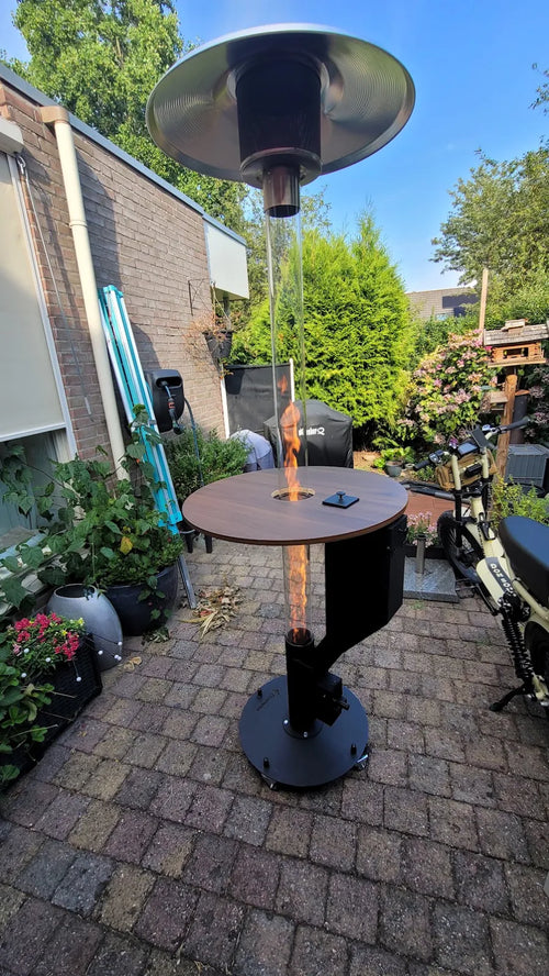 Pellethaard met rond tafelblad op een klinkerterras met veel potplanten