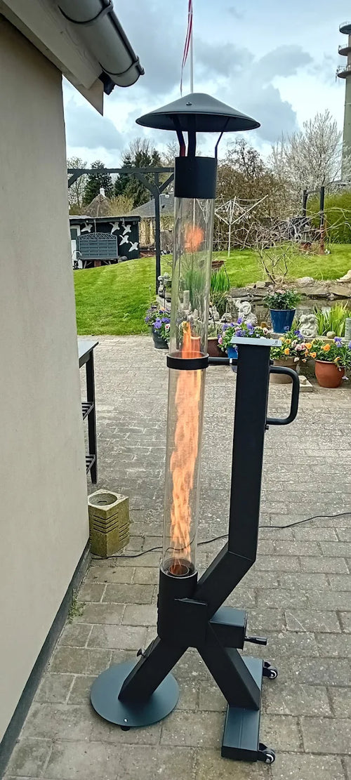 Flamesa pelletterrasverwarmer brandt op een klinkerterras langs de gevel van een woonhuis