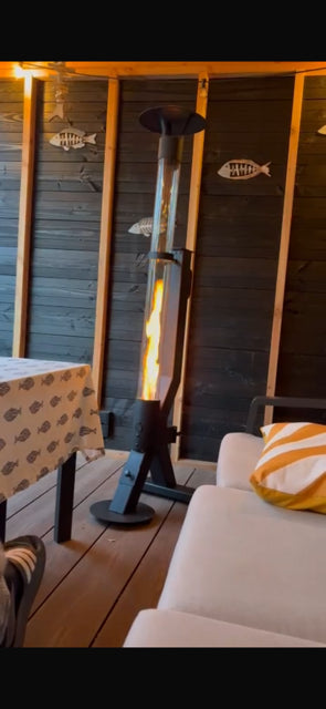 Flamesa terrasverwarmer op pellets brandt in een houten tuinhuis met witte loungebank en kussens
